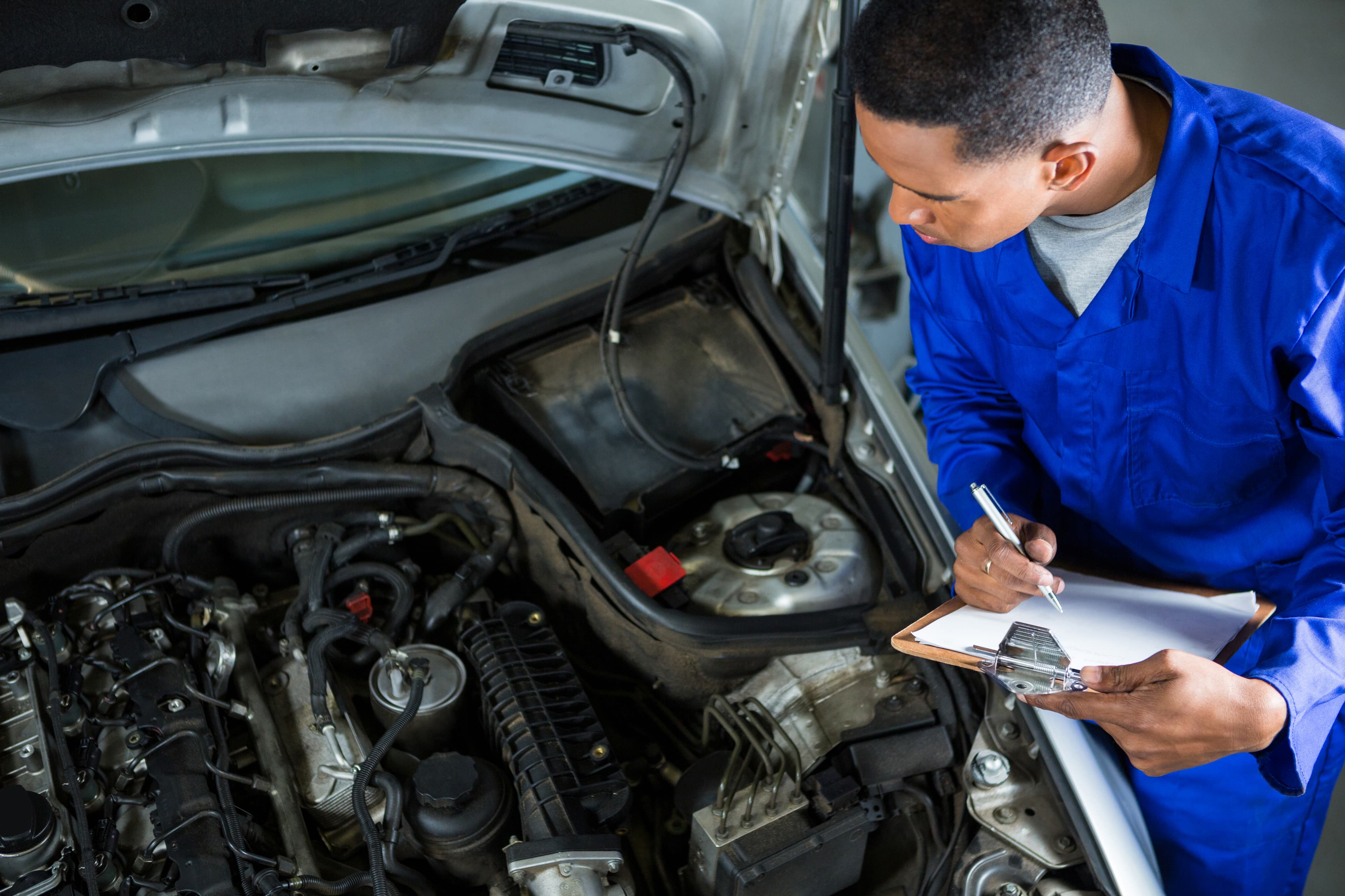 Mechanic inspecting a used car before listing